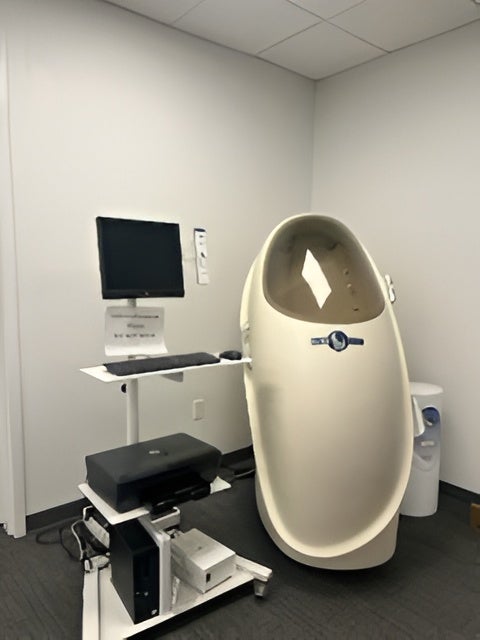 COSMED Bodpod body composition tracking pod next to a computer monitoring cart